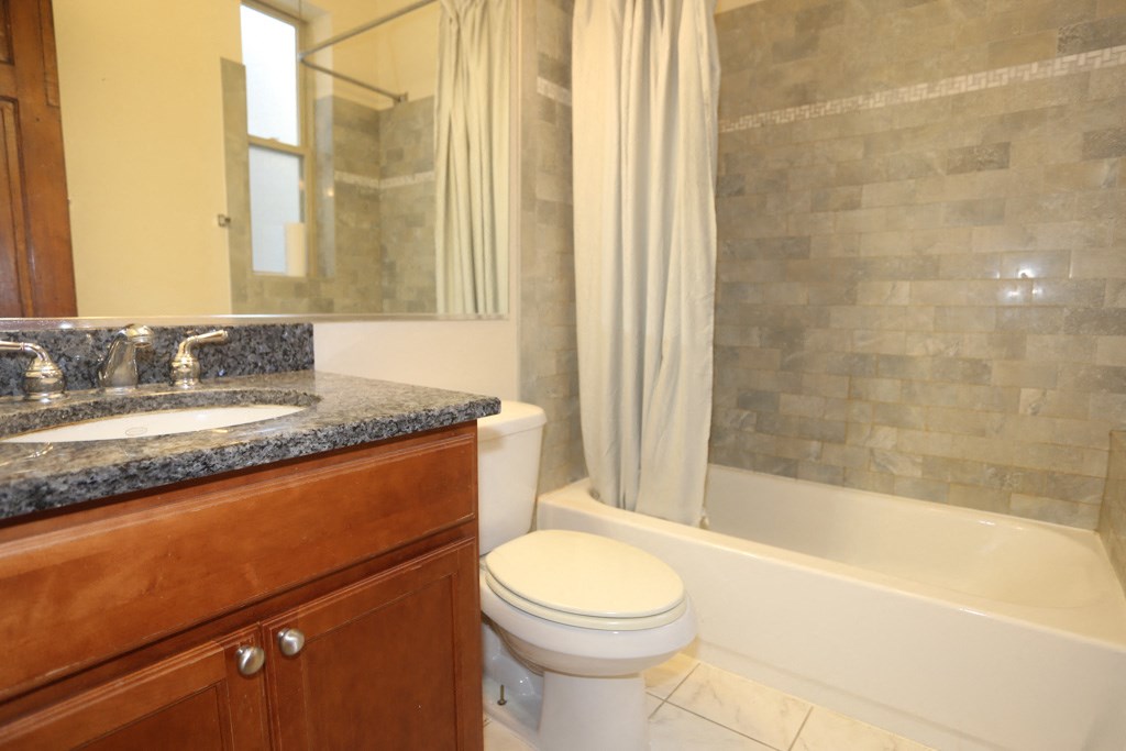 a bathroom with a toilet and a sink and a bath tub