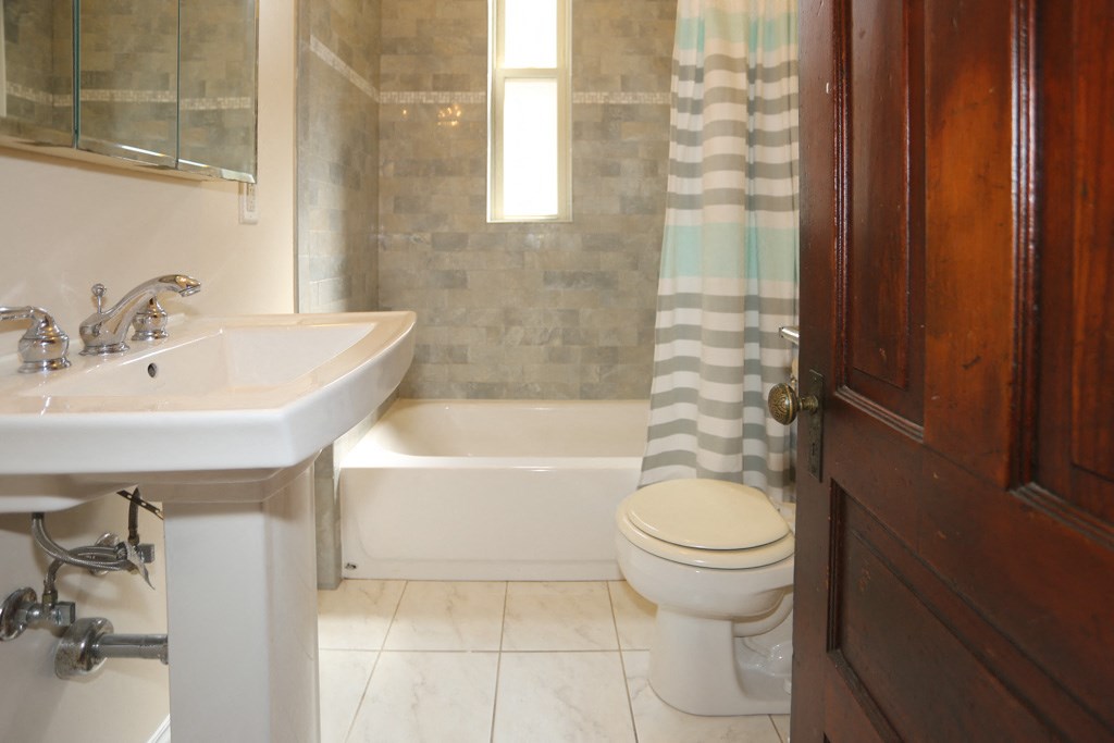 a bathroom with a toilet and a sink and a shower curtain