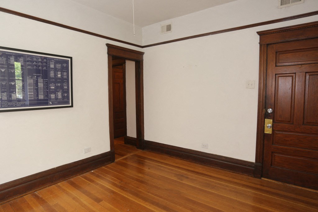 a room with wooden floors and a white wall and wooden doors