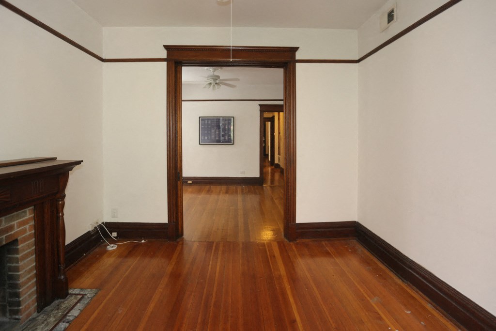 a living room and hallway with wood floors and a fireplace