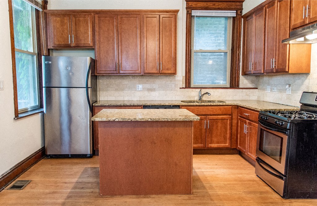 a kitchen with wooden cabinets and stainless steel appliances