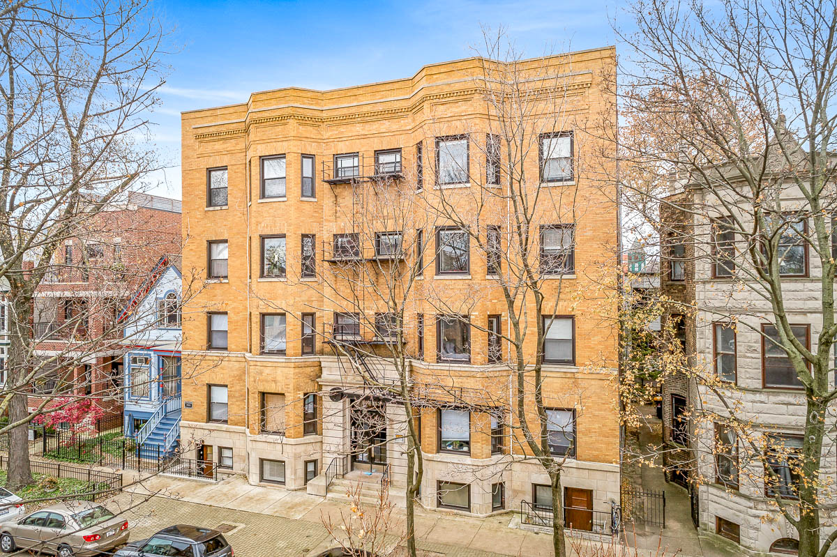 a tall brick building with cars parked in front of it