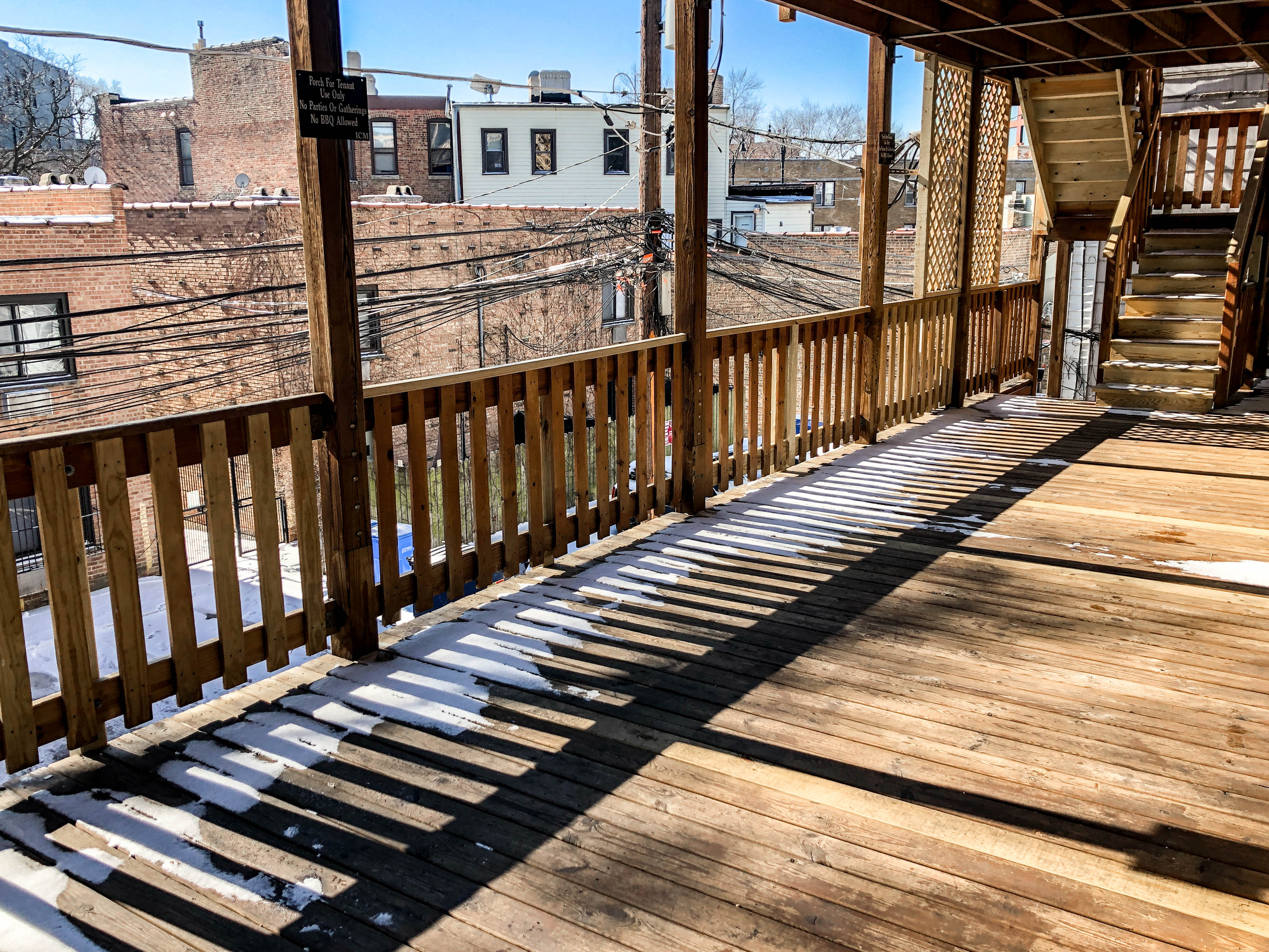 a wooden deck with a view of a city in the snow