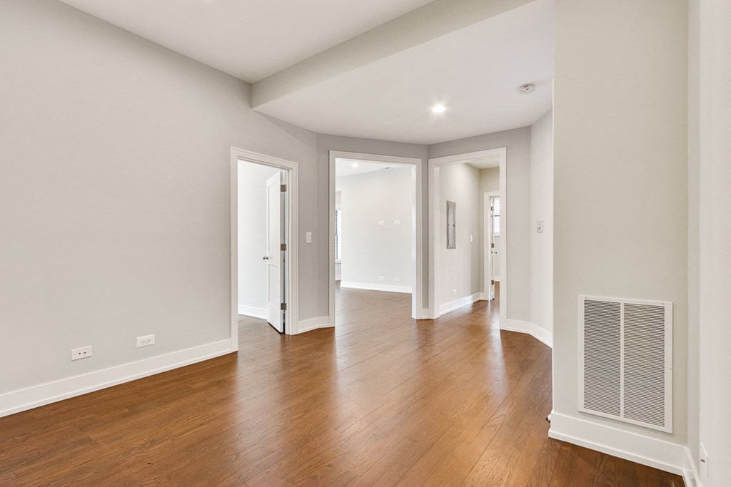 a renovated living room and hallway with wood floors and white walls