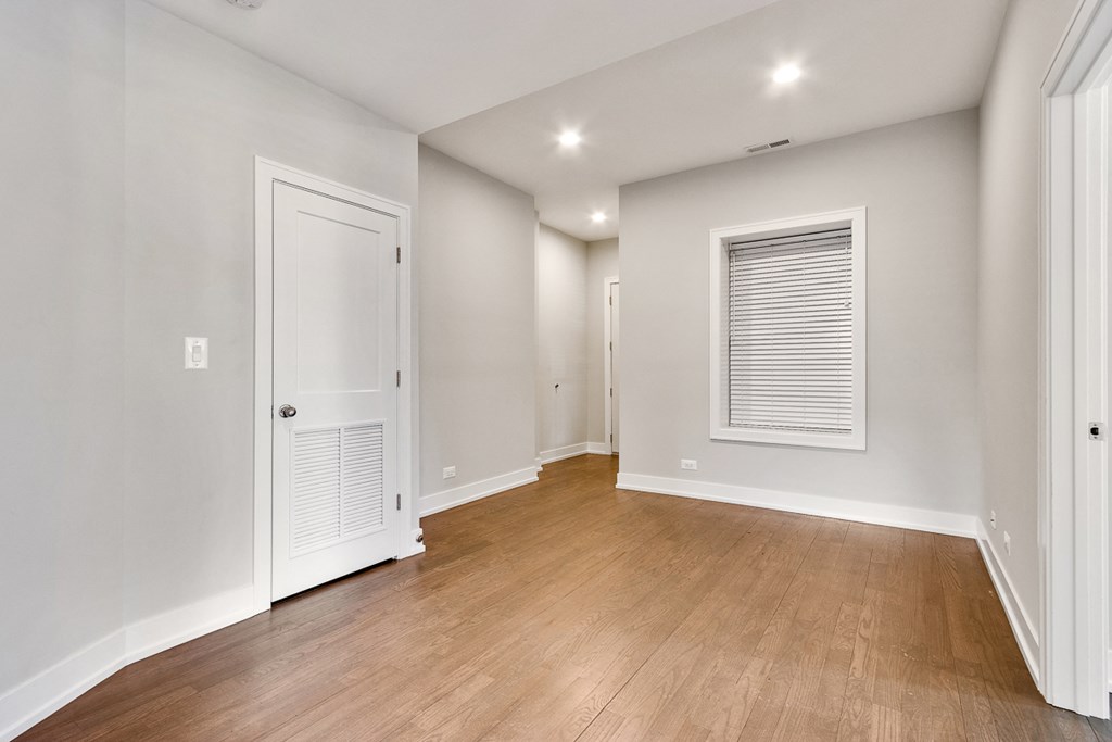 a renovated living room with white walls and wood flooring