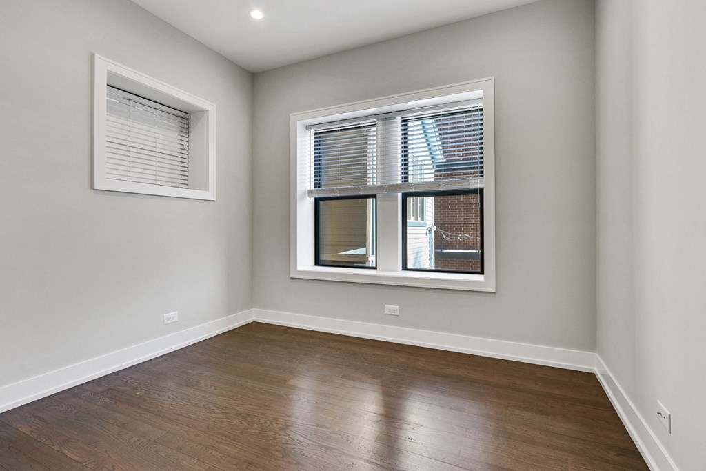 an empty room with wood floors and a window