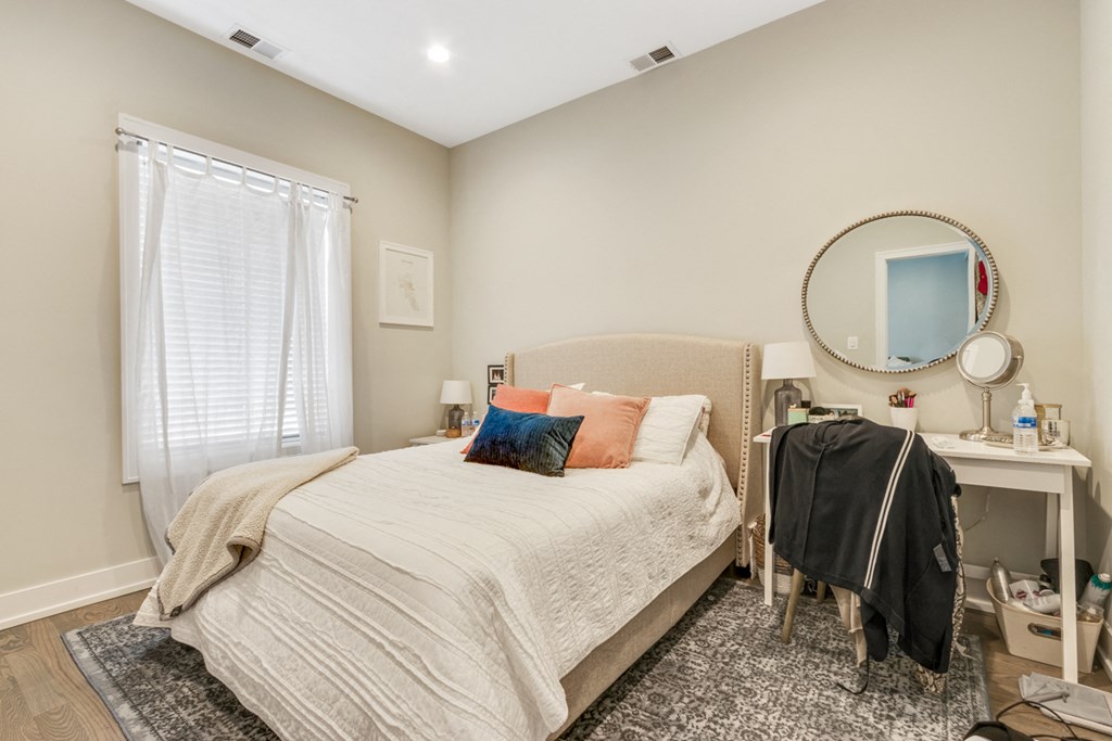 a bedroom with a bed and a dresser with clothes on it