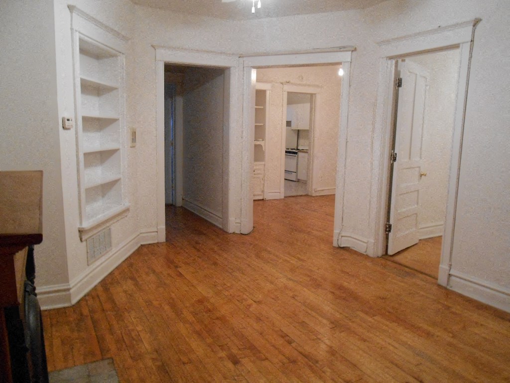 a living room with a hard wood floor and white closets