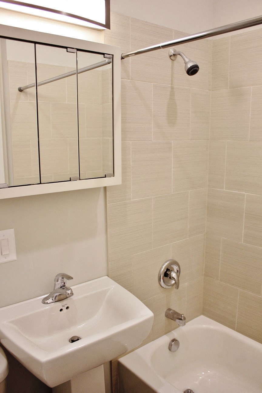 a bathroom with a sink and a shower and a mirror