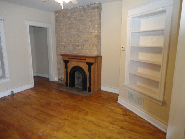 a living room with a fireplace and a wooden floor