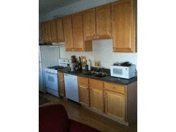 a kitchen with white appliances and wooden cabinets