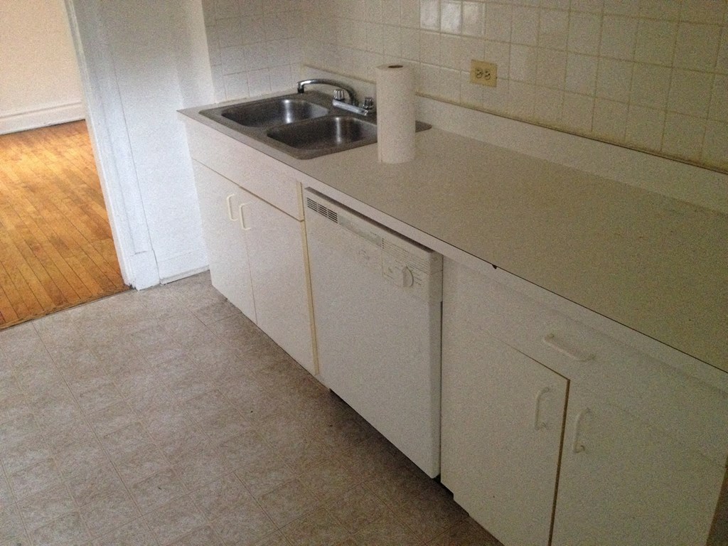 a kitchen with a sink and a paper towel on the counter