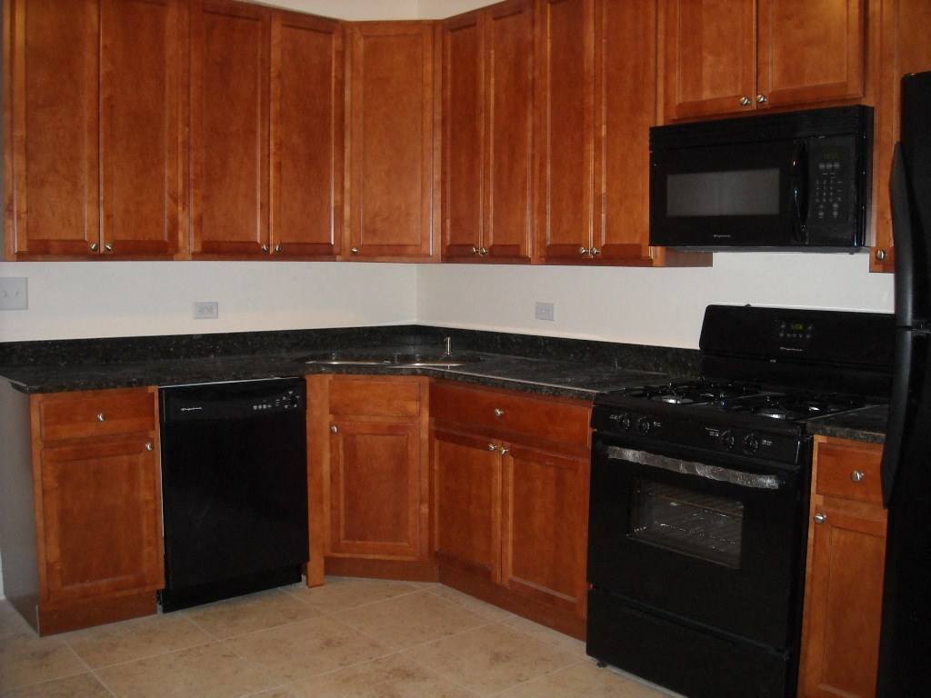 a kitchen with black appliances and wooden cabinets