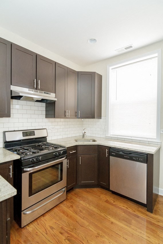 a kitchen with stainless steel appliances and dark cabinets