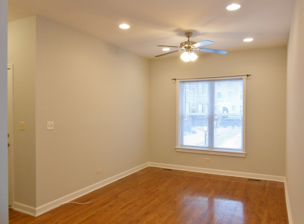 a empty room with a ceiling fan and a window