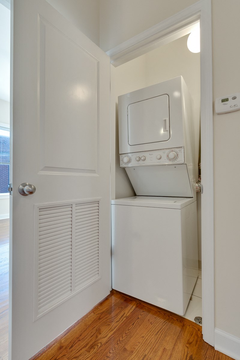a laundry room with a washer and dryer and a door to a closet