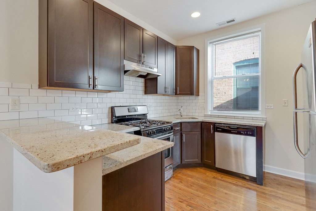 an updated kitchen with stainless steel appliances and wooden cabinets