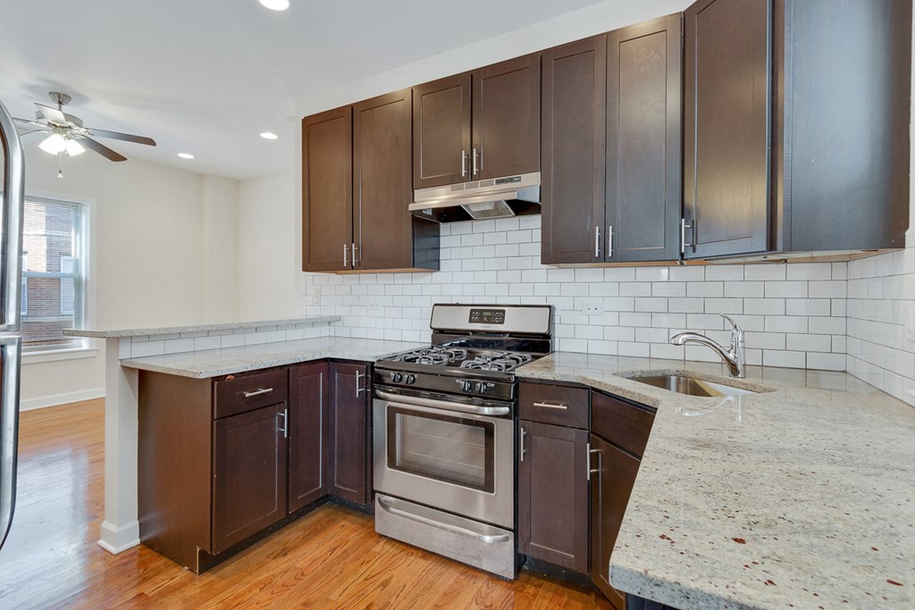 an updated kitchen with stainless steel appliances and marble counter tops