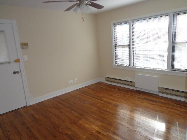 an empty room with a ceiling fan and two windows