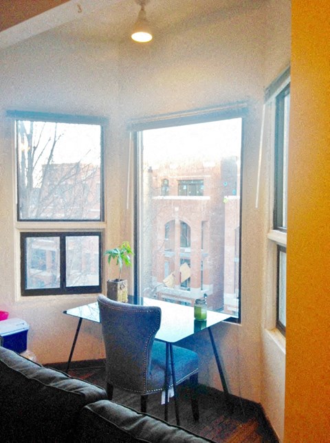 a living room with a table and chairs in front of a window