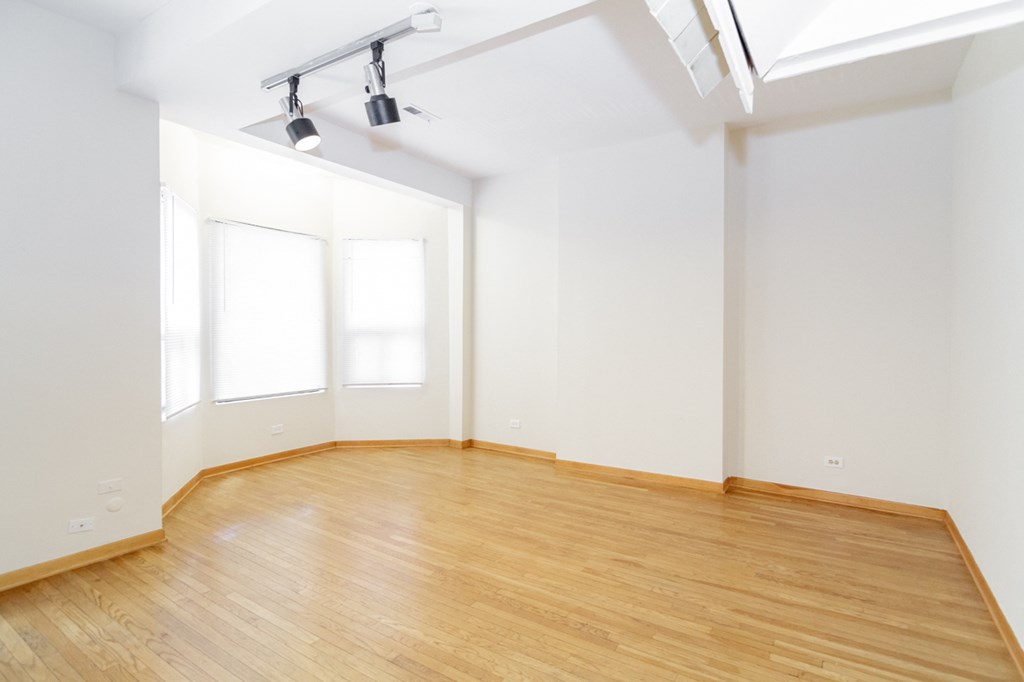 an empty room with wood floors and white walls