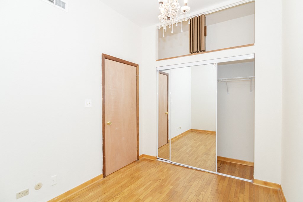 an empty room with a mirror and a closet