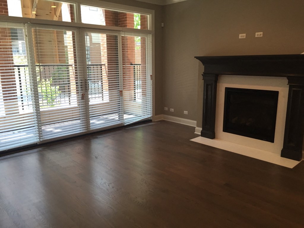 a living room with a fireplace and wooden floors