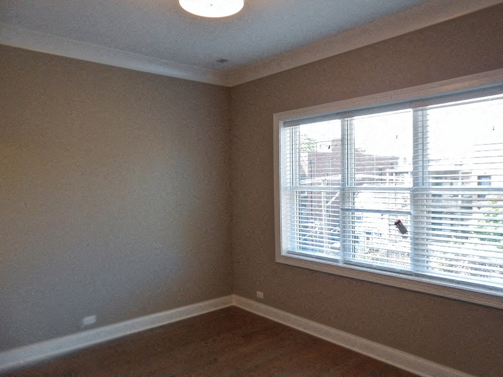 a living room with a large window and a wooden floor