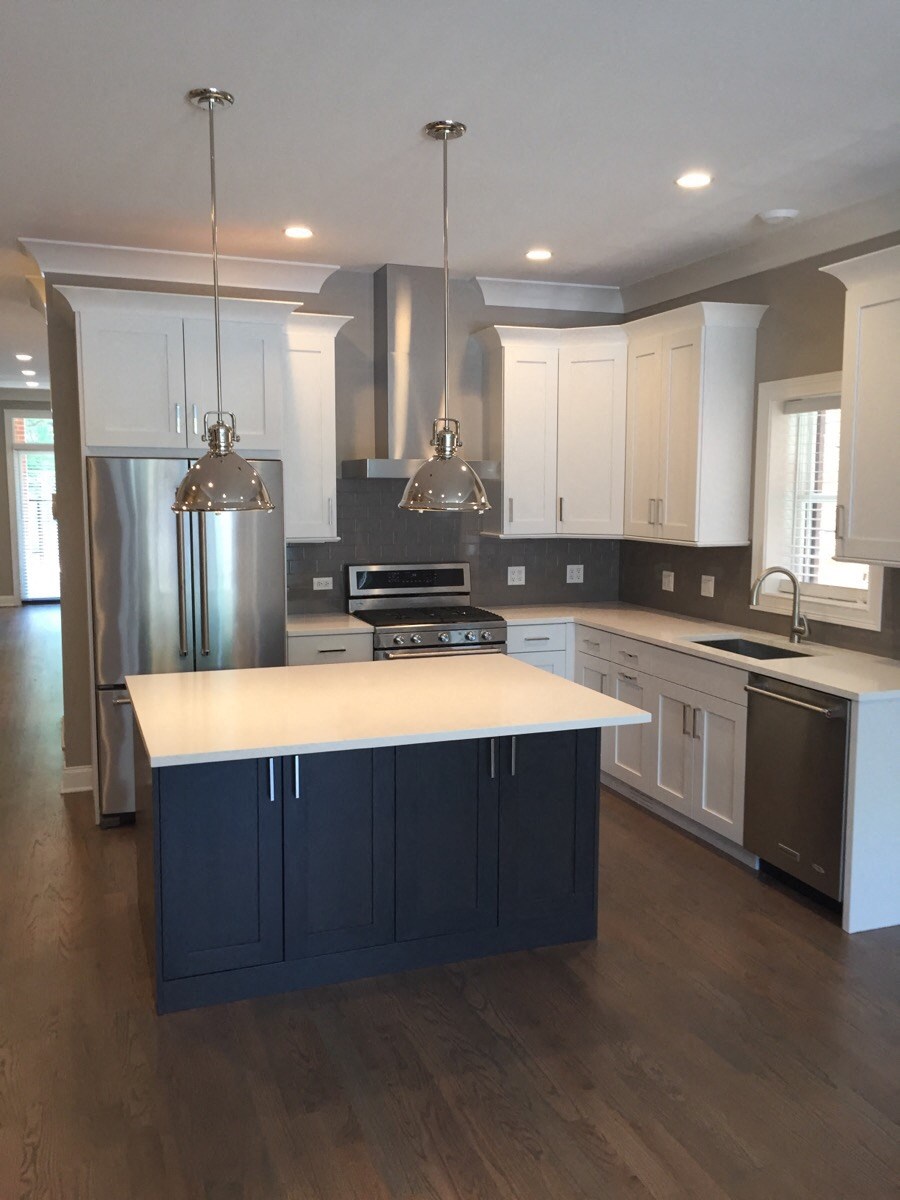a recent kitchen remodel with white cabinets and stainless steel appliances