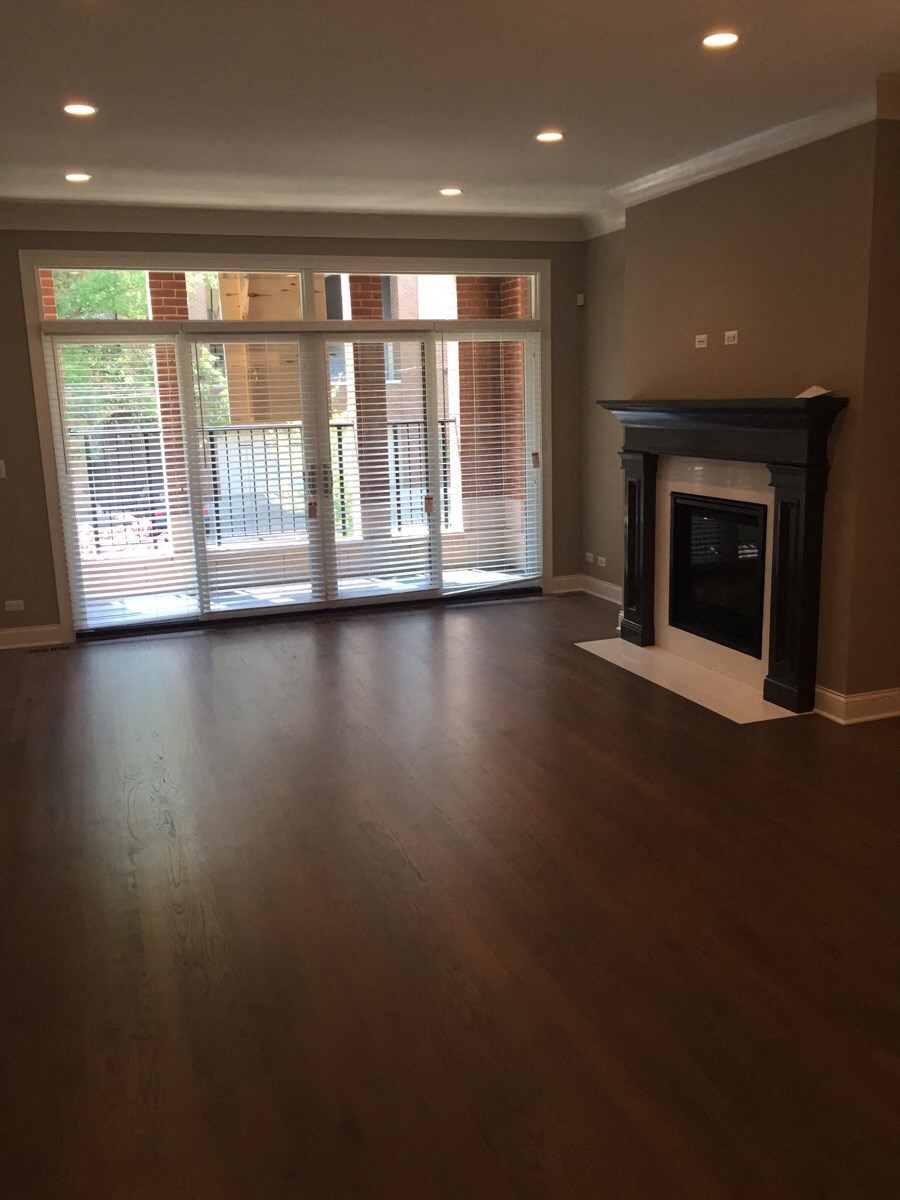 an empty living room with a fireplace and a large window