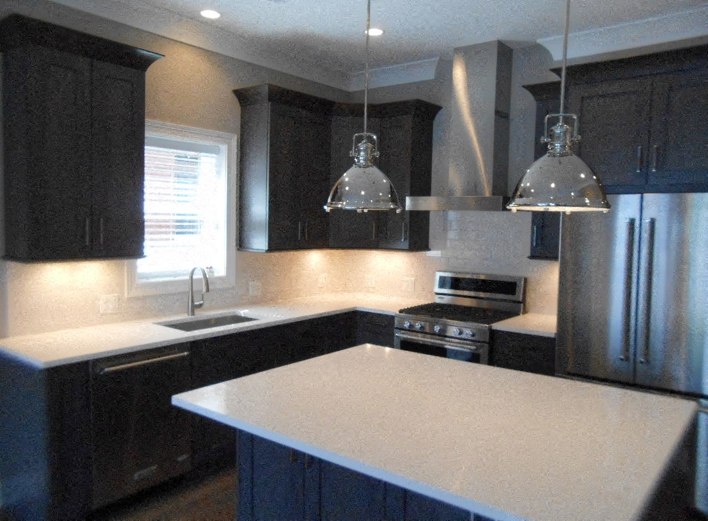 a kitchen with black cabinets and a white counter top