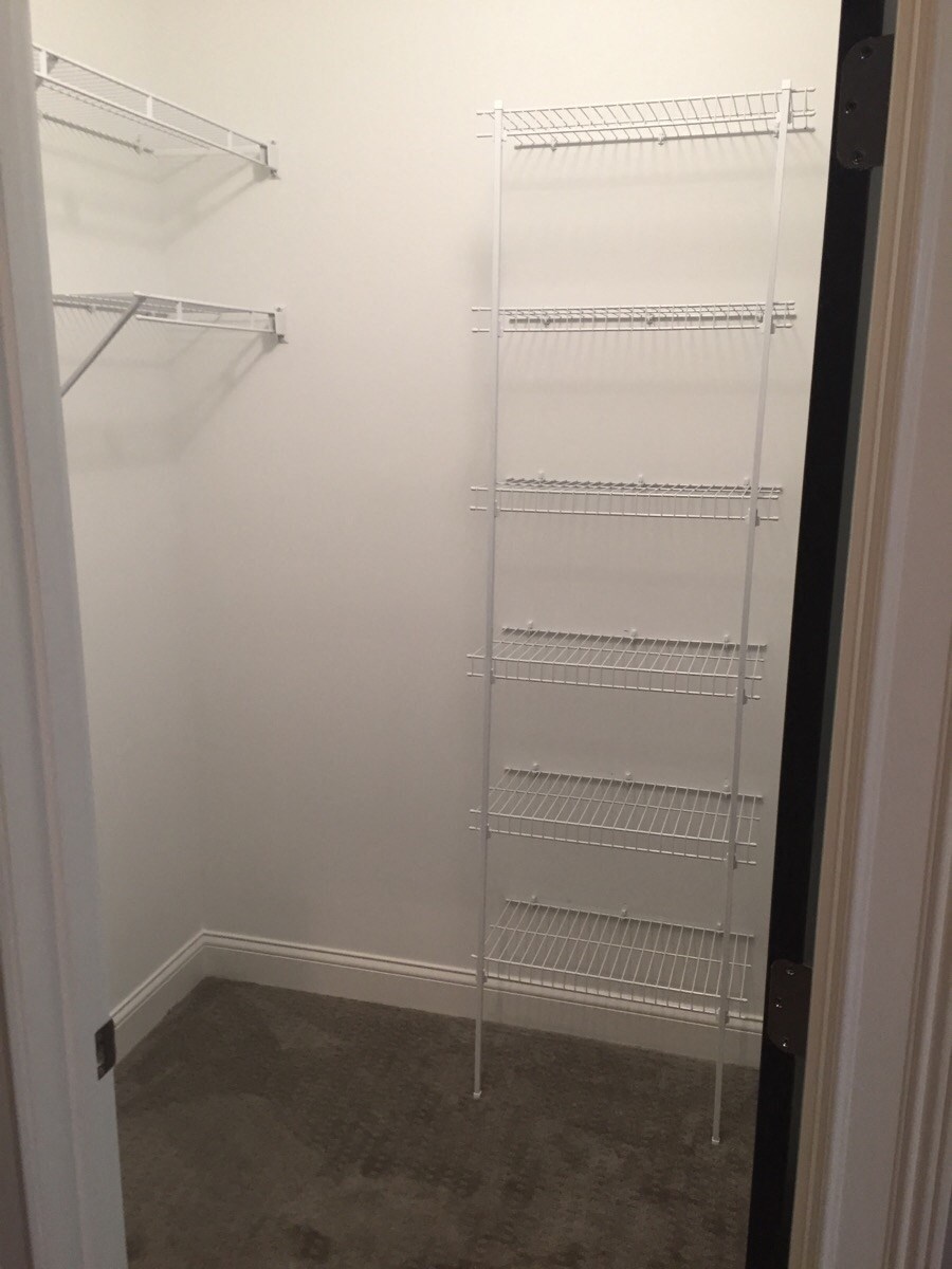 a small closet with white walls and a white closet door