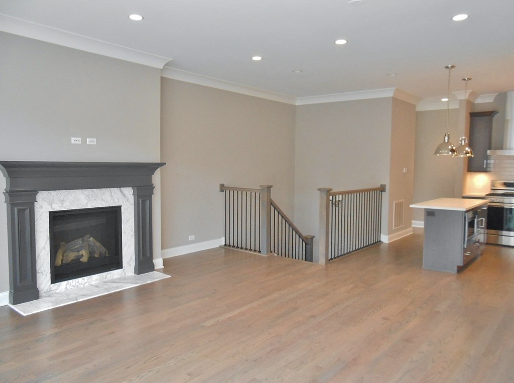 an empty living room with a fireplace and a staircase