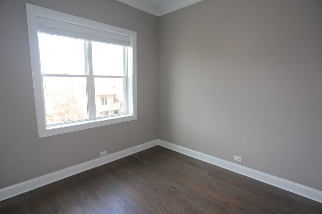 an empty room with a window and wooden floors