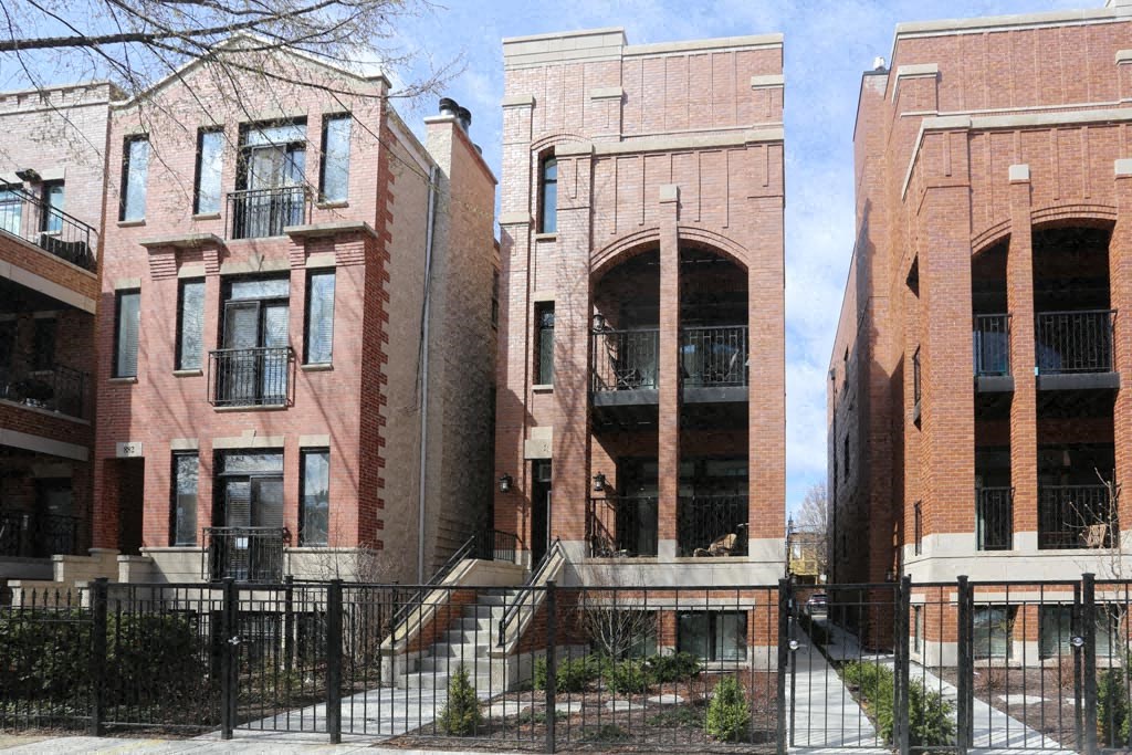 a row of brick buildings with steps and a fence