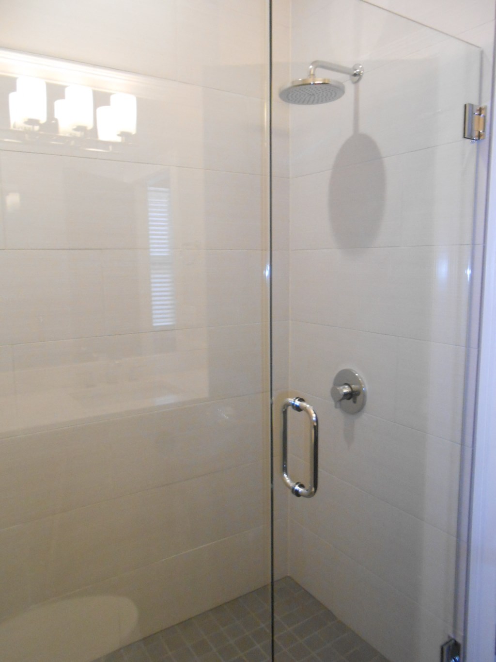 the shower in the master bathroom has a glass door