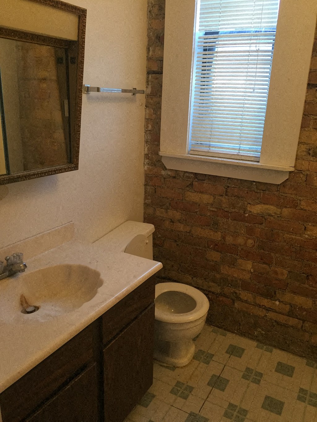a bathroom with a sink and a toilet and a window