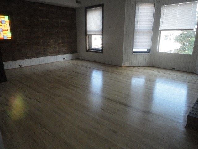 an empty living room with wood floors and windows