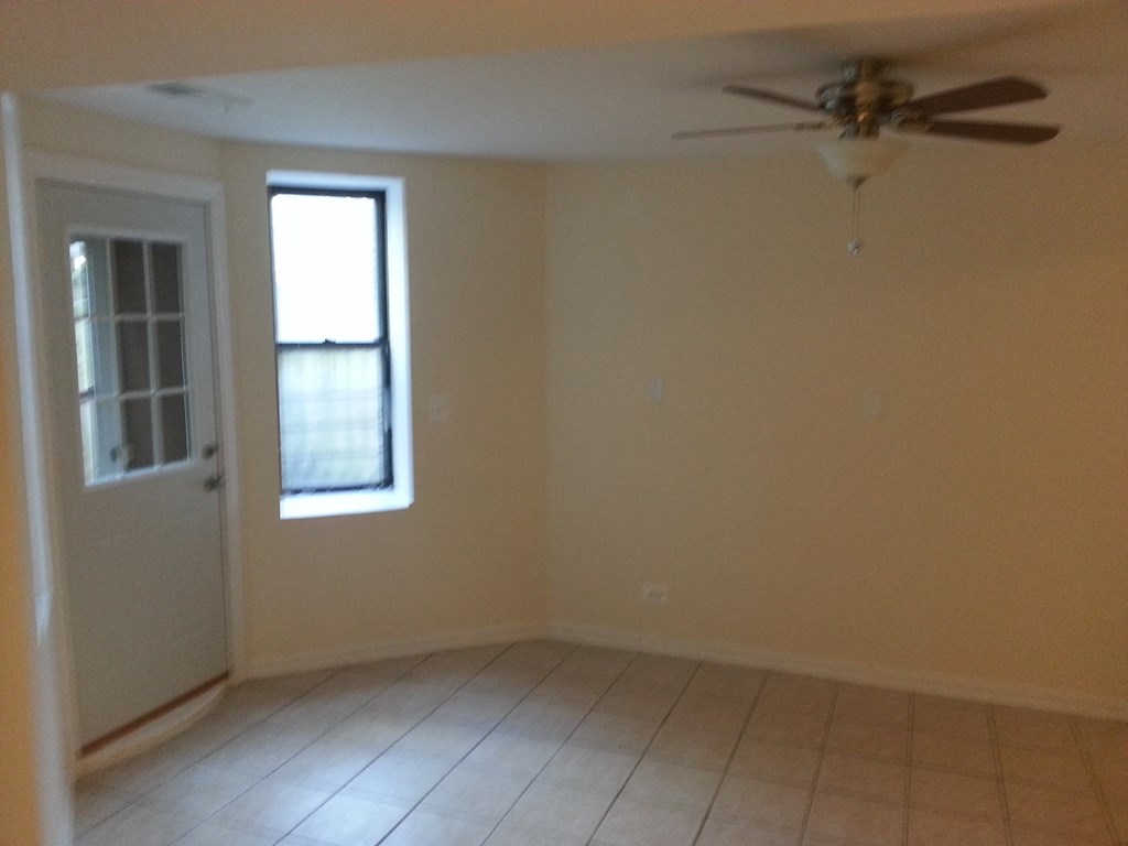 an empty living room with a ceiling fan