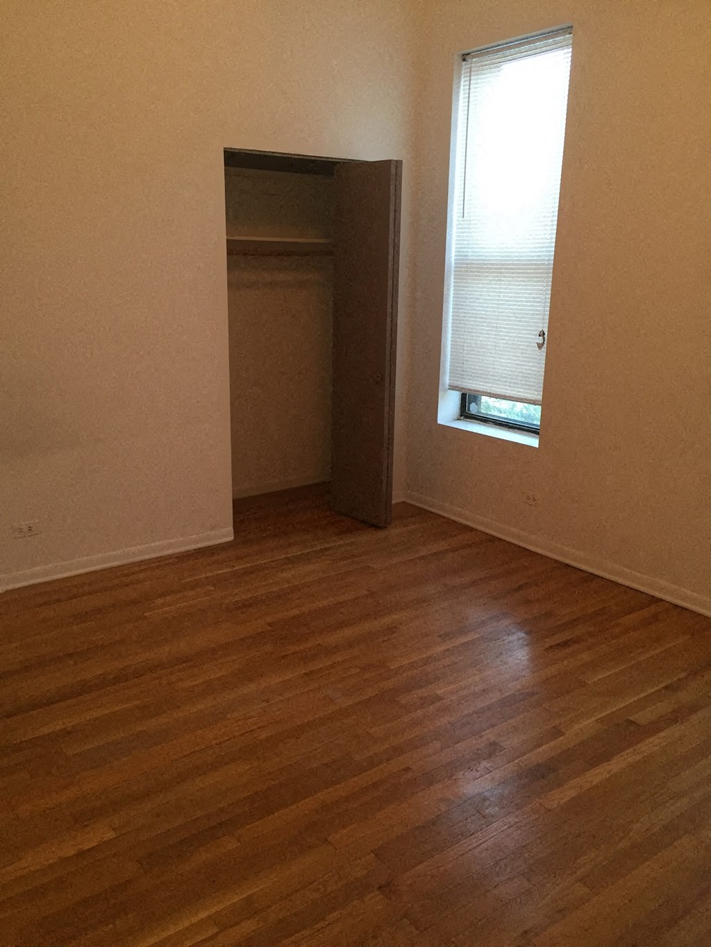 an empty room with a wooden floor and a window