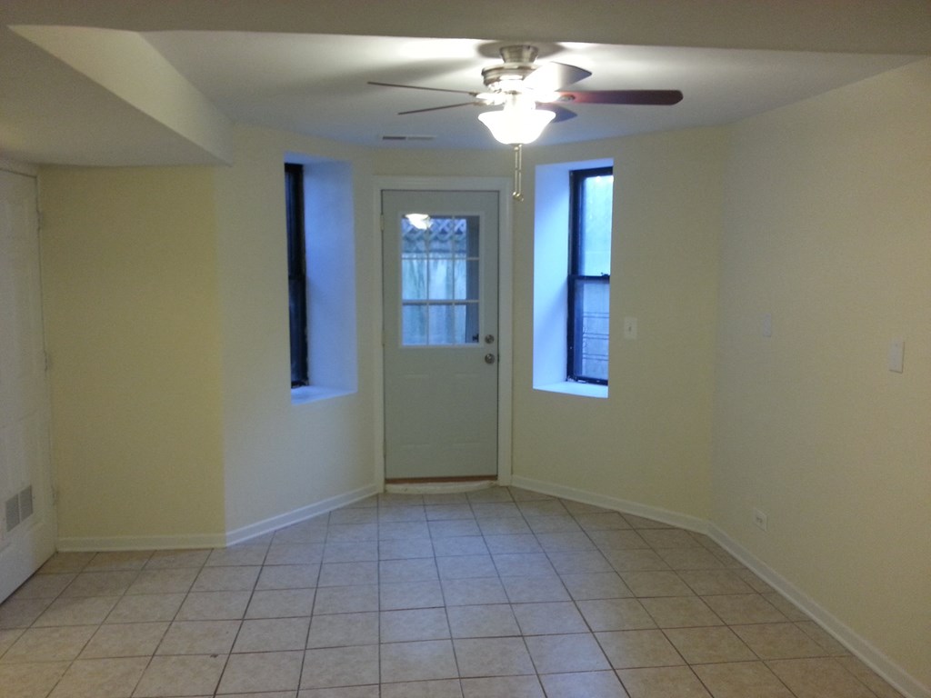 an empty living room with a ceiling fan