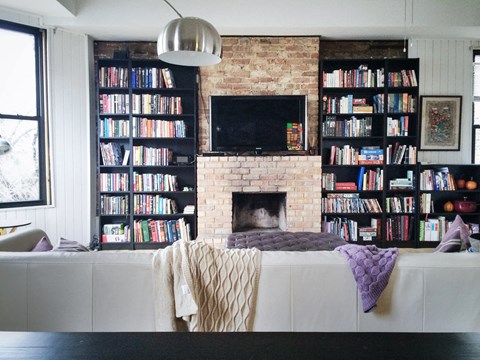 a living room with a white couch and a brick fireplace