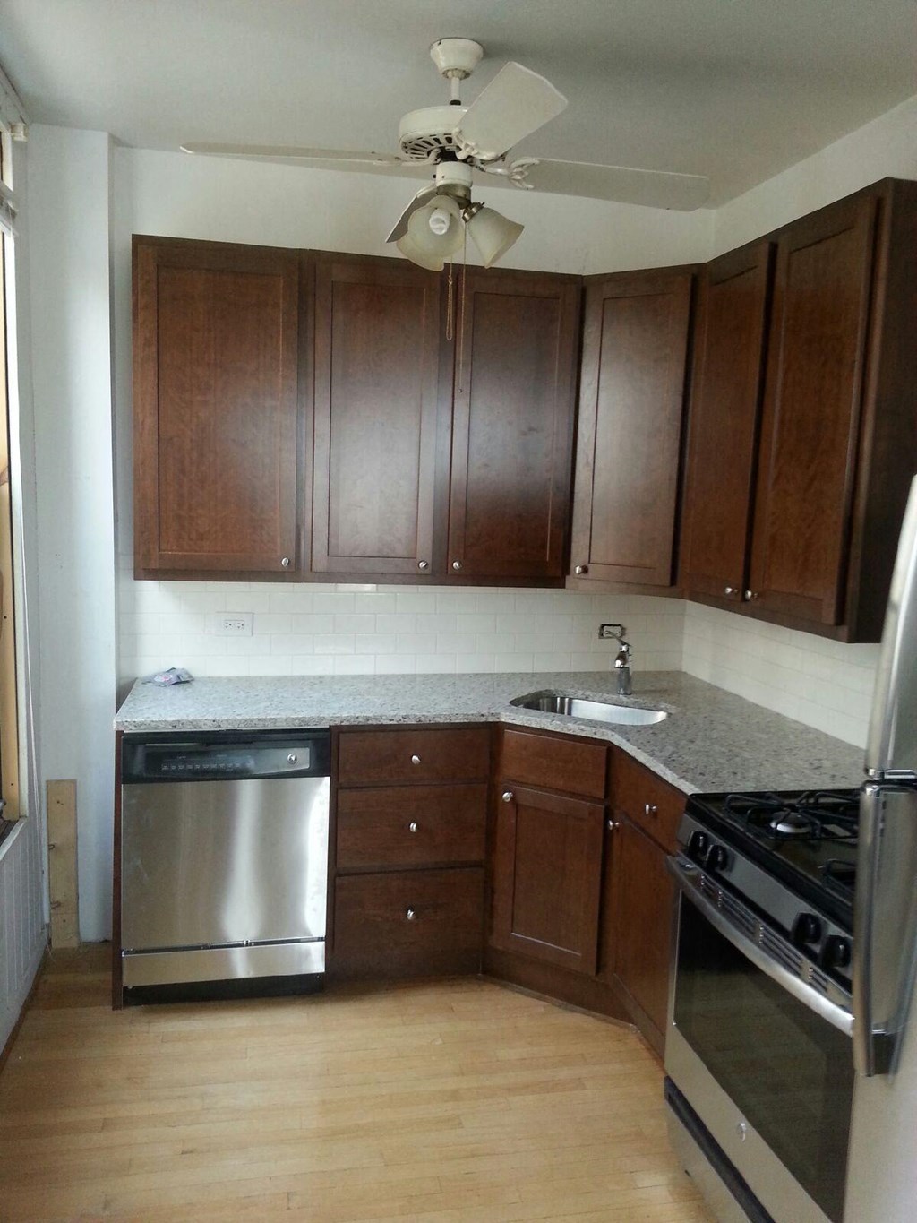 an empty kitchen with stainless steel appliances and wooden cabinets