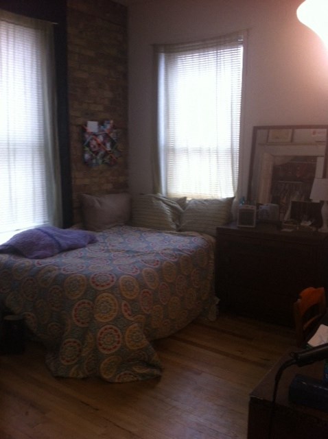 a bedroom with a bed and two windows