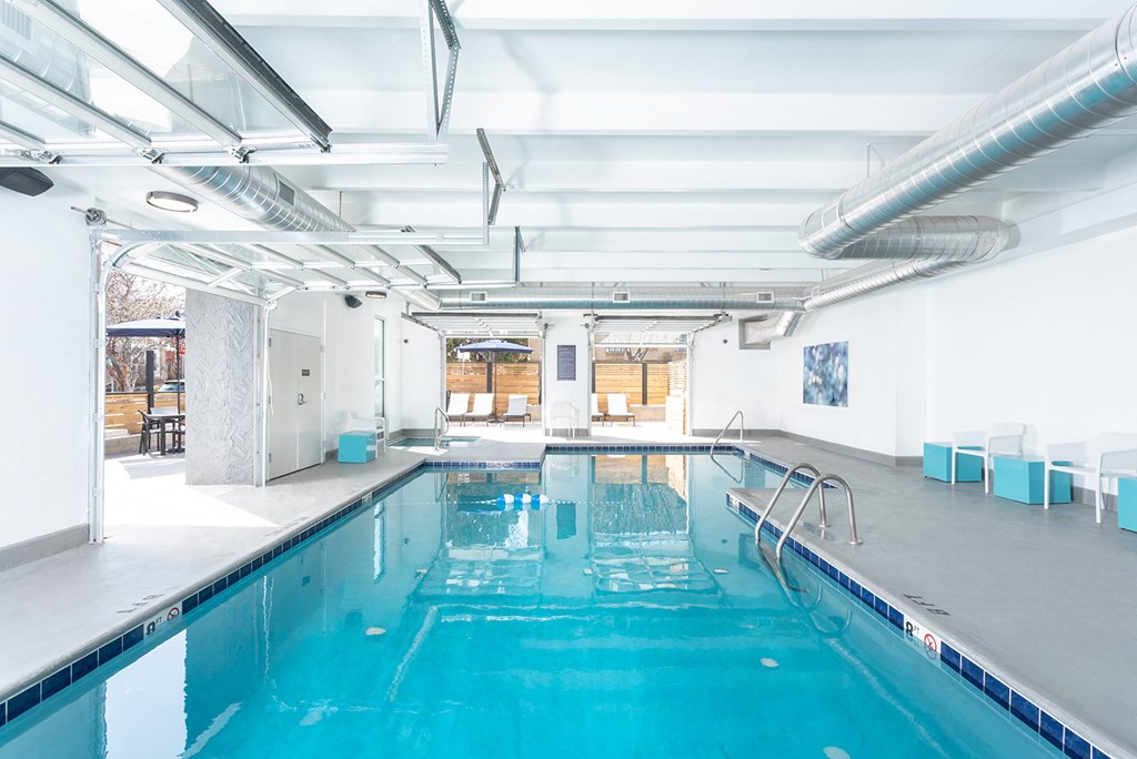 the indoor swimming pool is located in the center of a large room with white walls