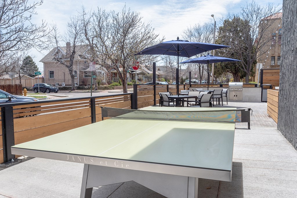 a table with umbrellas on a patio with tables and chairs