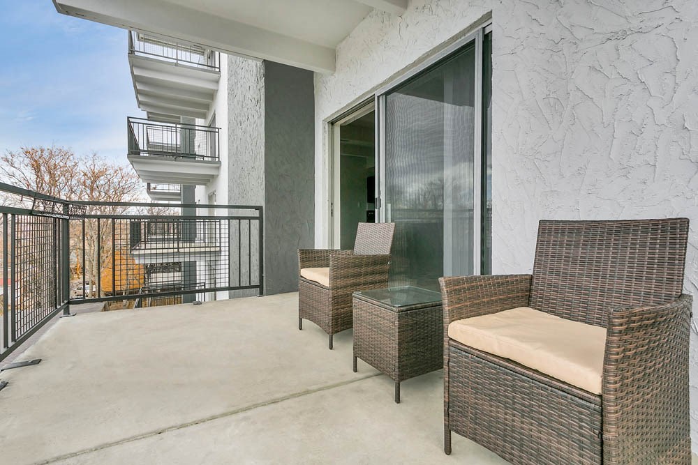 a patio with chairs and a table on a balcony