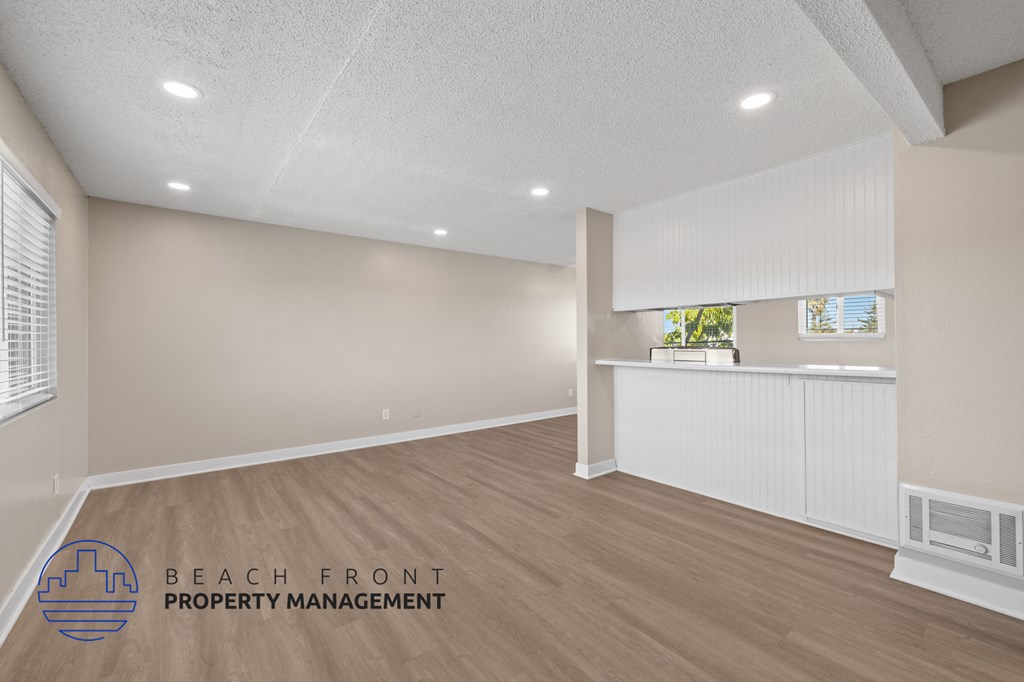A room with a logo of Beach Front Property Management on the floor.