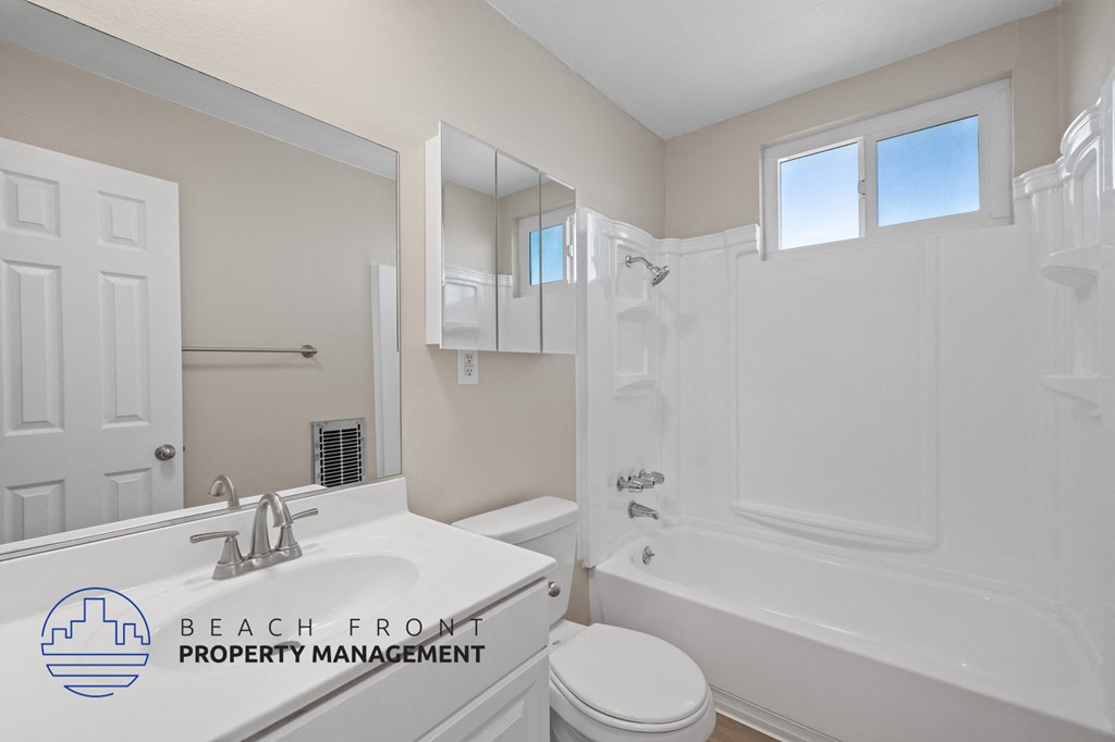 A bathroom with a sink, toilet, and bathtub.