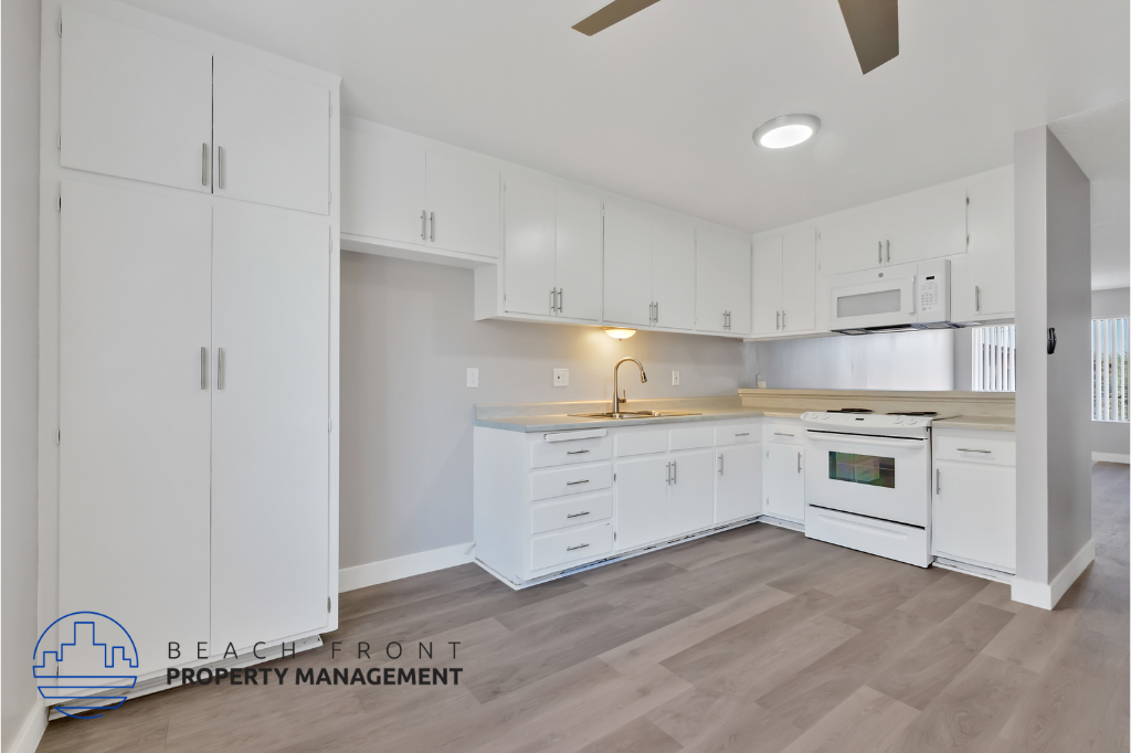 a white kitchen with white cabinets and a wood floor
